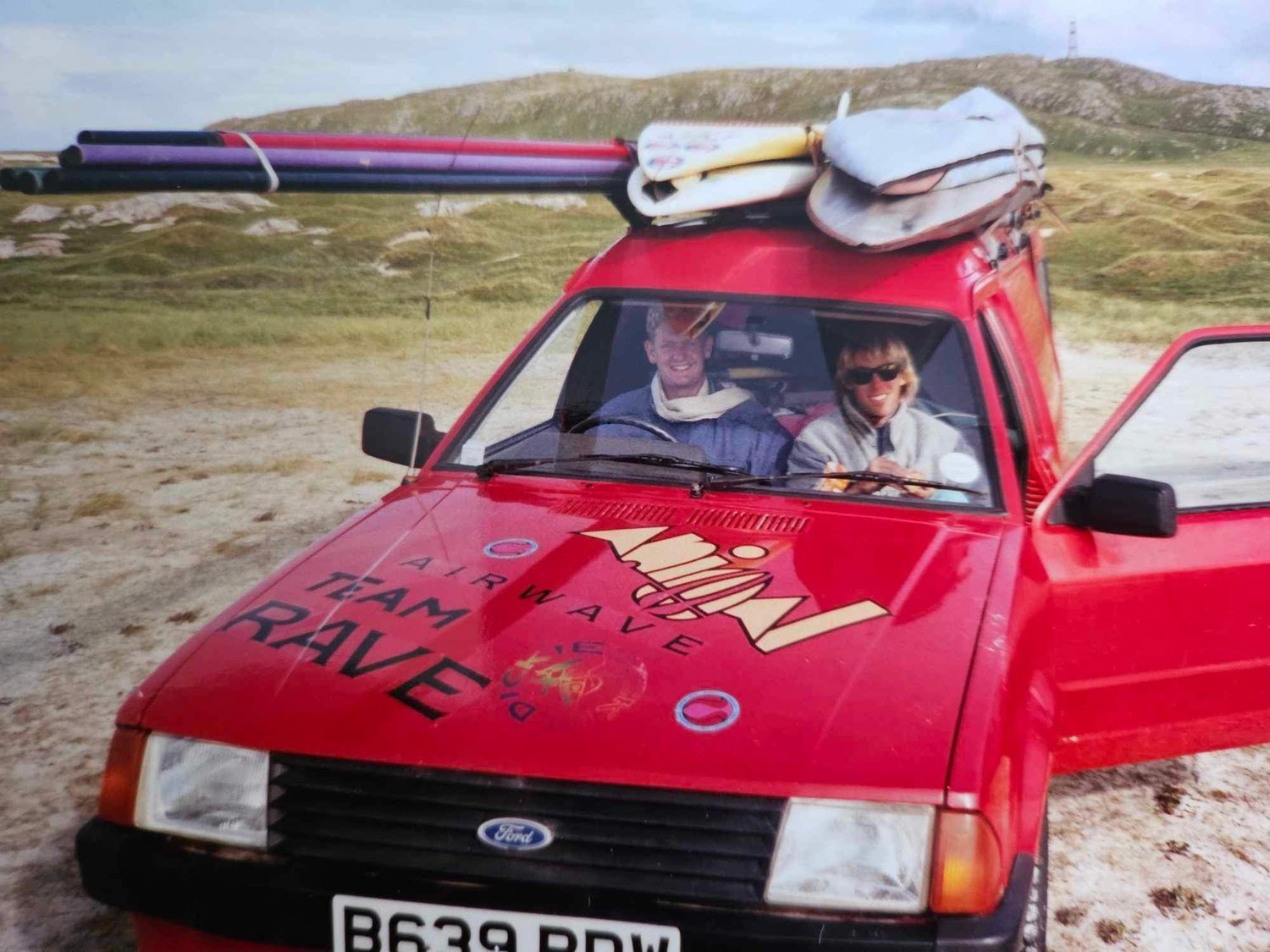 Archive photograph: a red Ford Escort with boards on the roof on Tiree
